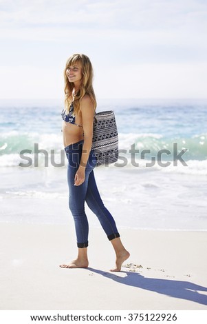 Beautiful blond woman walking on beach