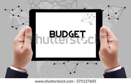 BUDGET text on the tablet pc screen held by businessman hands - online concept, top view