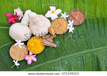 Ayurveda pads with powders, flowers on banana leaves . top view  Royalty-Free Stock Photo #375199255