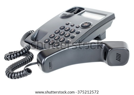 Picture of a business landline telephone with the receiver off the hook laying in front of the phone