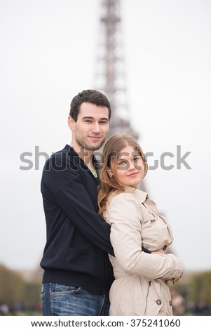 young couple, man and woman standing in front of Eiffel tower, Paris, France, hugging