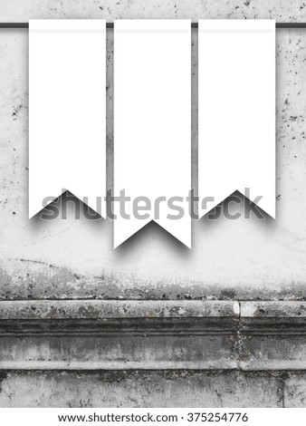 Close-up of three hanged medieval standard flags with rod on weathered grey wall background