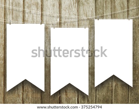 Close-up of three hanged medieval standard flags with pegs on brown vertical wooden boards background