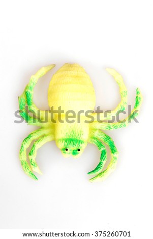 Yellow toy spider on a white background