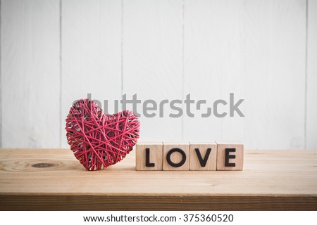 Red heart yarn with "love" in cube on wood table