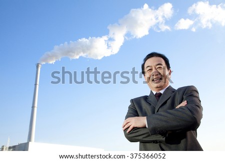 Businessman in Front of Smokestack