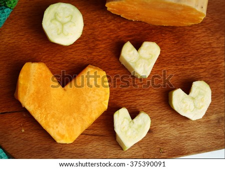 cut pumpkin and courgette in heart form image as food stylish decoration to valentines day dinner 