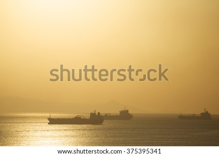 View sunrise over the calm sea with ships at anchorage