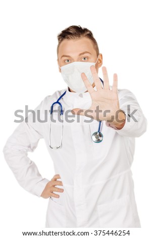 Young  male doctor in white coat and stethoscope making stop sign. People and medicine concept. Image isolated on a white studio background.