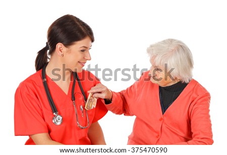 Picture of a senior woman paying money  for medical service