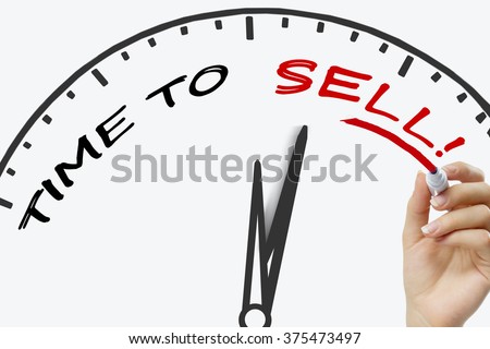 Hand writing time to sell concept with red marker on transparent wipe board. Royalty-Free Stock Photo #375473497