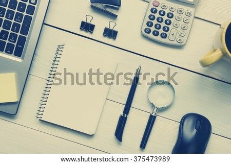 Office desk table with supplies and coffee cup. Top view. Copy space for text. Toned image.