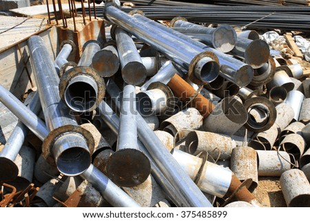 Metal pipe piled up together in the construction site, closeup of photo
