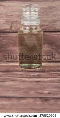 Corn vegetable cooking oil in vial glass over wooden background
