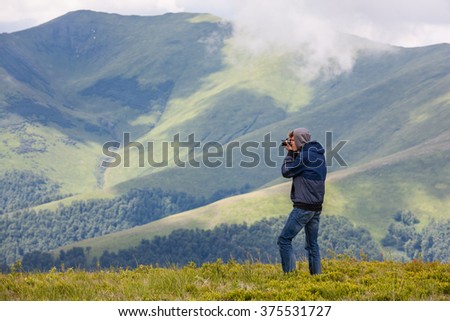 Male traveler taking pictures with his point and shoot camera
