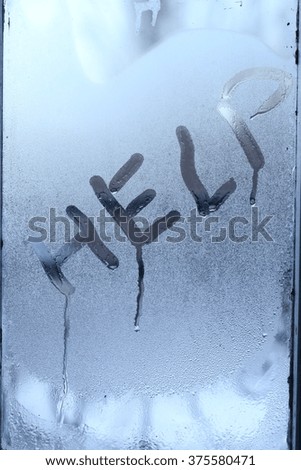 close-up inscription help on the frozen winter glass
