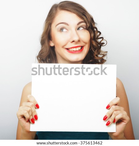Young curly woman holding blank card