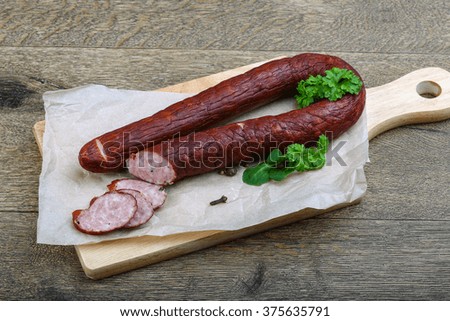 Fresh meat sausage with slices and parsley leaves