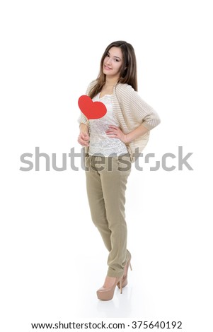 Full length portrait of attractive happy smiling teen girl with red heart, love holiday valentine symbol over white background