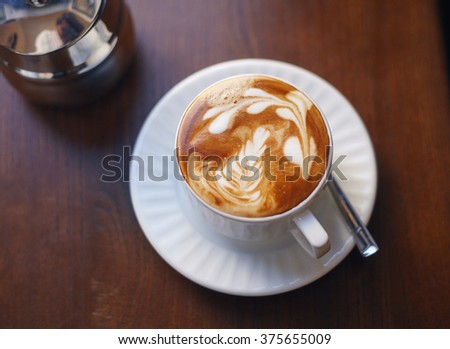 Close up picture of a cup of coffee with a picture on it.