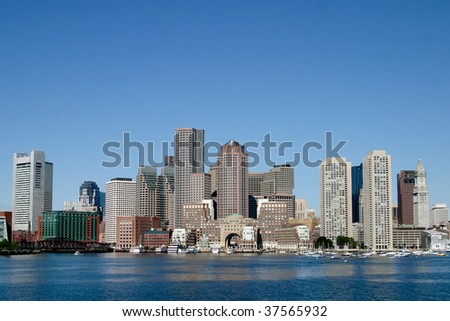 Boston skyline from water with a blue sky