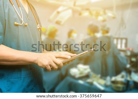 Male doctor,medical students or surgeon using  tablet and laptop during the conference,Health Check with digital system support for patient,test results and information  registration,selective focus Royalty-Free Stock Photo #375659647