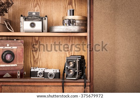 Hipster cameras. Vintage cameras on wooden cupboard. Photographers atelier.