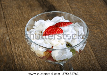 Fruit salad with cream served strawberry