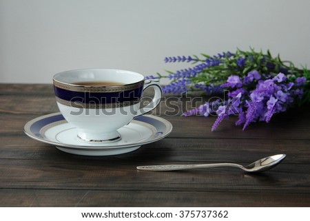 Still life with tea cup on saucer, lavender and silver tea spoon. Top view. 