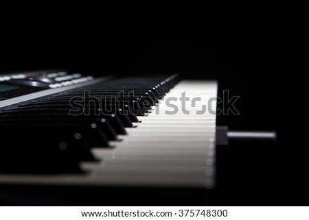 Piano keys in shadow on black background
