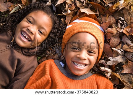 Kids lying on leaves Royalty-Free Stock Photo #375843820