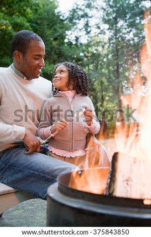 Father and daughter by fire