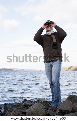 the man using binoculars