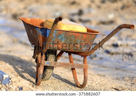 Rusty old wheelbarrow-artificial pond for water evaporation-salt mound beside the E.shore on the S.section of the c.100 km2-102 ms.below sea level-160 ms.deep Lake Afrera. Danakil-Afar region-Ethiopia