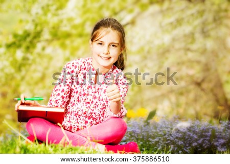 Young girl reading a book outdoor