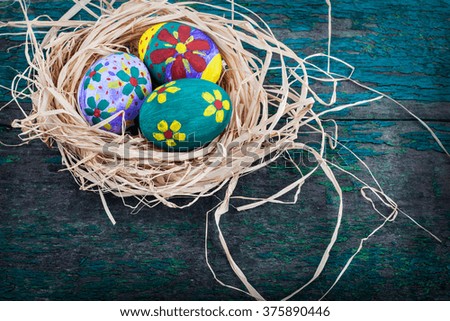 Easter eggs in nest on rustic wooden planks. Holidays background 