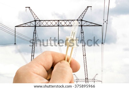 Halogen lamp in hand on the background Power lines
