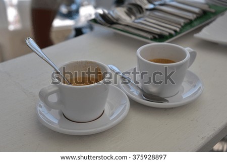 Two white cups with espresso on table