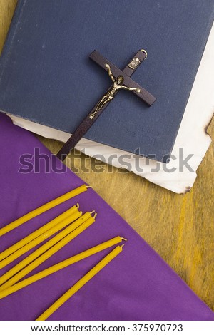 Thin candles on purple cloth used in religion and ancient tomes.
