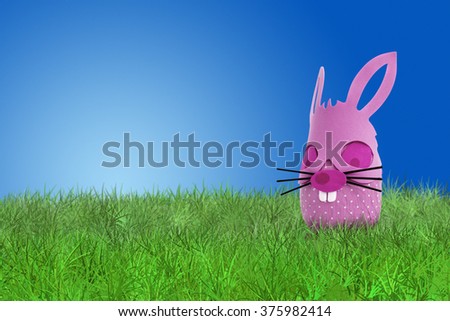 Funny pink Easter bunny on grass on blue background