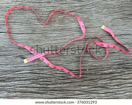 Pink measure tape make heart sign background