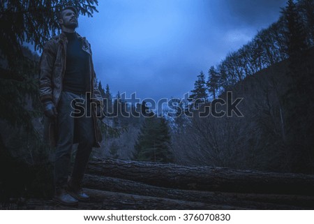 Young man in the forest at night. Early morning