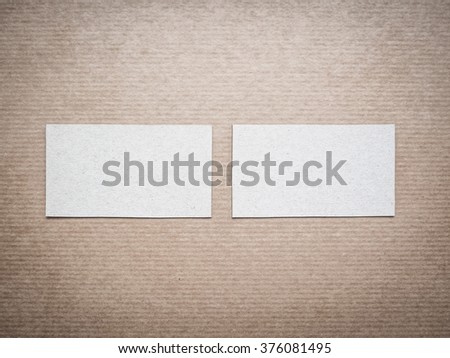 Two blank cardboard business cards on kraft background