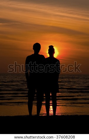 Couple in silhouette watching the sunset