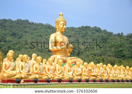 Big Golden and thousand of Golden Buddha statues with green mountain background
