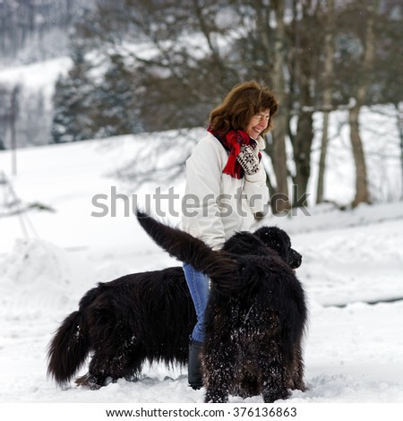 Woman with two big water-dogs in snow field