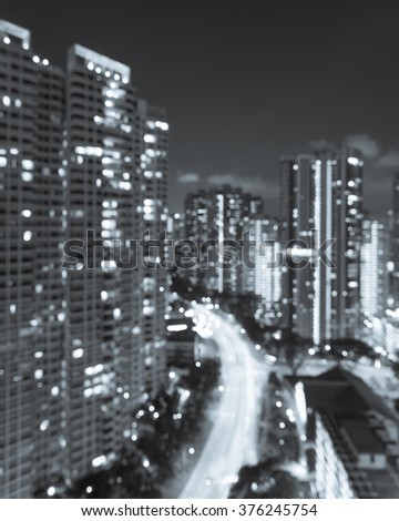 Blurred abstract background aerial view of Toa Payoh neighborhood in Singapore at night. Colorful bokeh from high-rise apartment buildings lights and car headlights in highway. Black and White tone