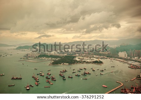 Victoria Harbor aerial view and skyline in Hong Kong with urban skyscrapers and boats.