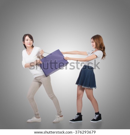 Two Asian girl fighting for shopping bags.