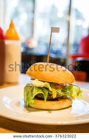 Beautiful, Juicy and Fragrant Burger in Cafe on Wooden Table, Vertical
